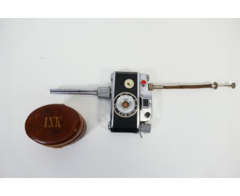 A small leather bound travelling inkwell and a novelty cigarette lighter in the form of a camera. [W]