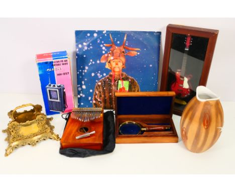 A mixed lot to include: An Asmuse Kalimba thumb piano with metal hammer, "Wham - Last Christmas" Pudding Mix record, a framed