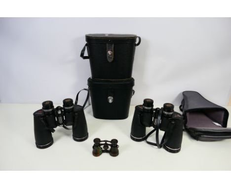Two pairs of cased 7 x 50 magnification Chinon binoculars, a pair of lacquered brass opera glasses, and an empty soft case fo