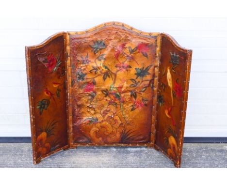 A vintage leather three fold firescreen decorated with exotic birds amongst foliage, approximately 92 cm x 121 cm. [W]