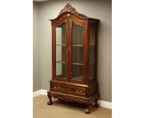 French style mahogany display cabinet, carved shell and scrolled pediment above glazed arched doors, single drawer, on ball a