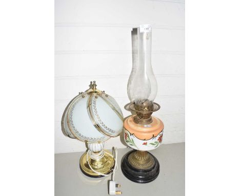 Oil lamp with floral glass font together with a modern metal based table lamp