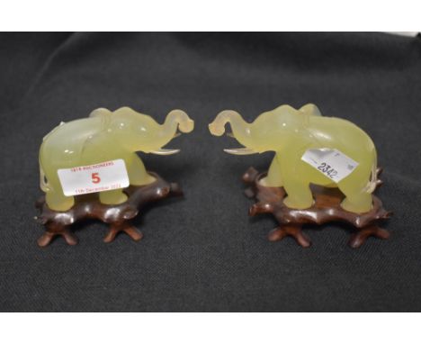 A pair of 20th century Jade stone mirrored elephant figures on wooden bases, 5cm tall approx