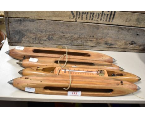 A group of four vintage wooden loom shuttles.