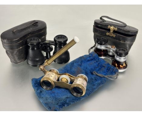 A pair of Edwardian ormolu mother of pearl mounted opera glasses decorated with engraved and gilded sprays with original blue