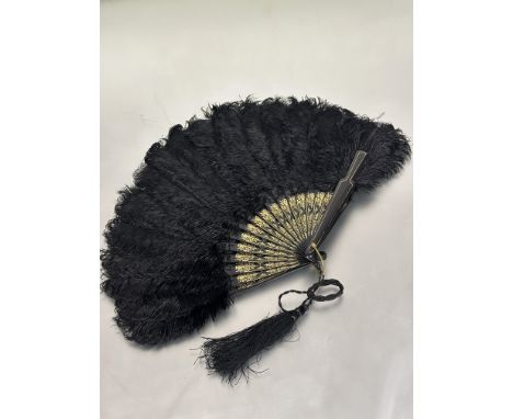 a Edwardian black lacquered and gilt stick ostrich feather evening fan with original cord and tassel no signs of damage or re