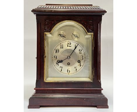 An early 20th century German bracket clock, the mahogany case with gadrooned caddy top above a arched and bevel glazed bezel,