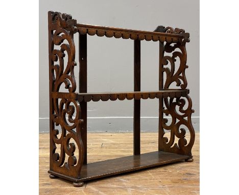 A Victorian oak three height table or wall rack, each shelf with a shaped and carved apron, with scrolling floral fret carved