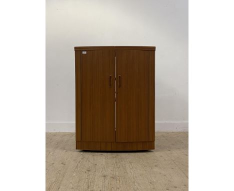 A mid century teak bow front cocktail cabinet / drinks bar, the top with fold over top to each side, being supported by hinge