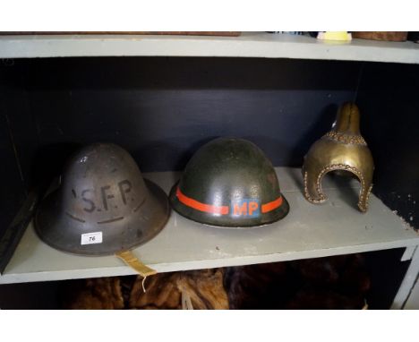 Two vintage helmets, one marked L.P. together with a unusual brass helmet.