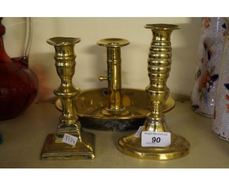 A Georgian style brass chamber stick together with two similar candlesticks.