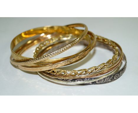 A collection of 9k and yellow metal bangles, of various designs and colours, and a silver bangle (6) weight of weighable gold