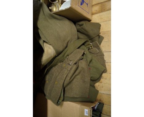 A mixed lot of assorted military uniforms, one for the Manchester Regiment also a metal military trunk.