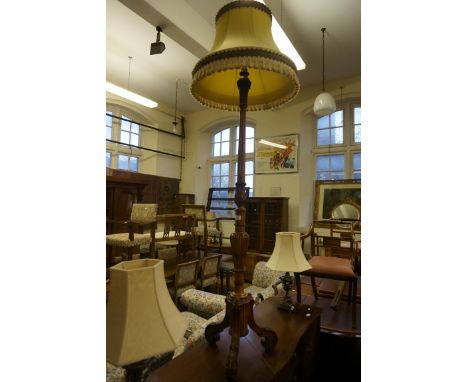 A period style carved and fluted standard lamp complete with pale golden shade with fringe, sold electrically untested.