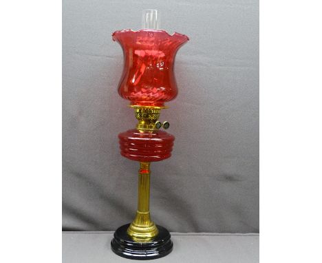 RUBY RED &amp; BRASS VICTORIAN OIL LAMP with black pot base, reeded brass column with ruby font and reproduction frilly edge 