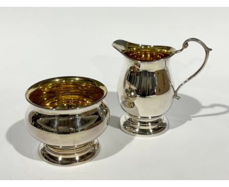 An Elizabeth II silver baluster cream jug and sugar basin, gilt interiors, skirted base, 10cm high, A.T. Cannon Ltd., Birming