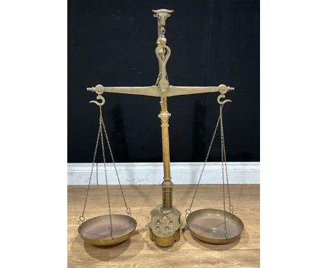 A large set of brass shop counter or apothecary balance scales, marked Manua, the suspension hook cast as a bull's head, 90cm