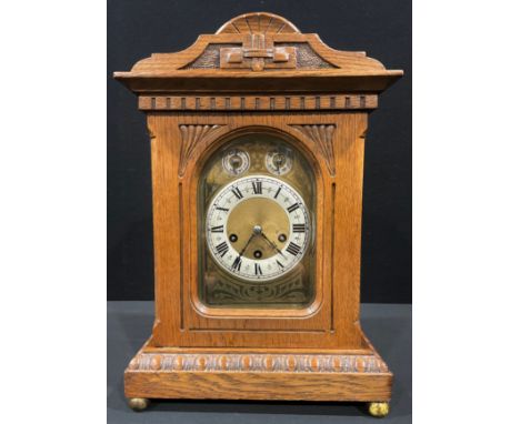 An Edwardian light oak mantel clock, arched case, silvered chapter ring with Roman numerals, pair of subsidiary chime/silent 