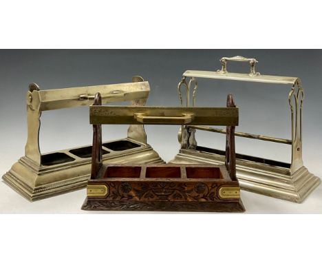 A Victorian oak three bottle tantalus, Betjemann's Patent London, 'The Tantalus', the mobile brass carrying handle locking an