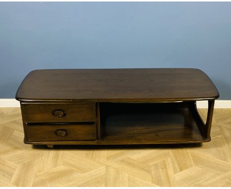An Ercol rectangular Pandora's box style coffee table with two drawers and raised upon castors, 125cms wide x 64cms deep x 40