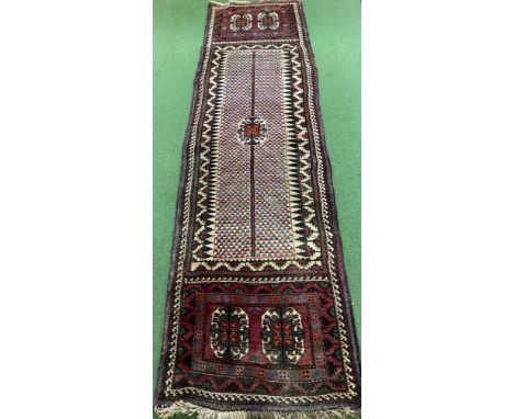 A hand made red ground wool runner decorated with geometric patterns, 295 x 80cm. Estimate: £40-60