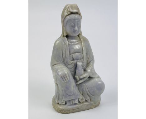 A Chinese Jade or hardstone carving of a seated Guanyin holding a vessel, 6cms wide x 4cms deep x 11.5cms high. Estimate £20-