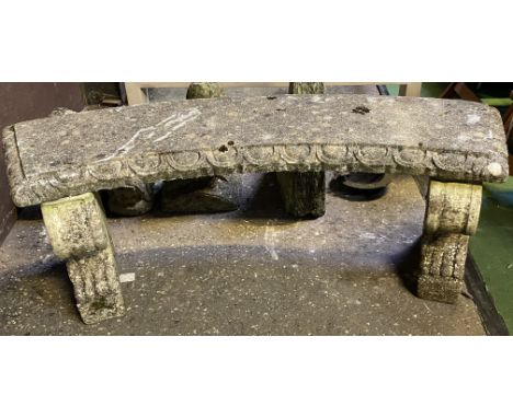 A weathered curved concrete garden bench with decorative end supports, 140cms wide x 40cms deep x 48cms high. Estimate £20-50