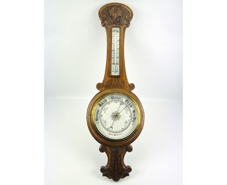 A carved oak cased aneroid barometer, circa 1900, 27.5cms high x 87cms high. Estimate £20-40.