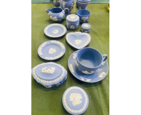 A collection of approximately fifteen Wedgewood blue jasperware boxes, a jug, pin trays and vases, tallest 13cms high. Estima