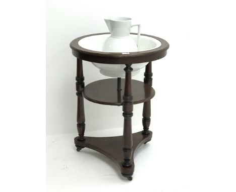 Early 19th century circular mahogany two tier washstand with ceramic bowl and jug, three turned supports, on brass and cerami