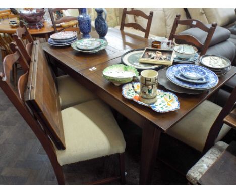 A reproduction oak extending dining table with two leaves and six matching ladder back dining chairs with upholstered seats 