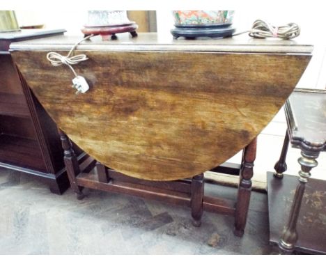 An oval oak gate legged table on turned legs, 39" wide