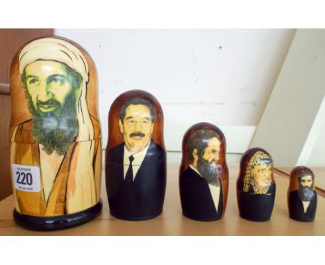 A set of five traditional Russian graduated cups painted with Bin laden, Saddam Hussein, Arafat and others