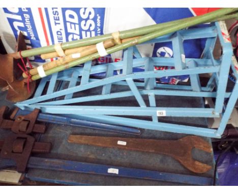 A set of car wheel ramps, two very large adjustable wrenches, post hole diggers, very large spanner etc 