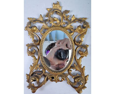 An antique early 20th Century brass ladies dressing table mirror having an ornate Italian Florentine / Rococo influenced fram