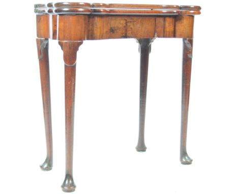 An 18th Century Georgian English antique mahogany dog ear card table / games table having a shaped fold over top with pull ou