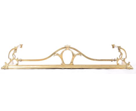 A 19th Century Victorian English antique Art Nouveau brass fire fender / fireguard having a sloped edge with typical art nouv
