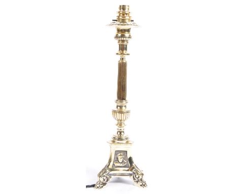 An early 20th Century English antique polished brass table lamp light. The lamp having a reed and urn column raised on a deco