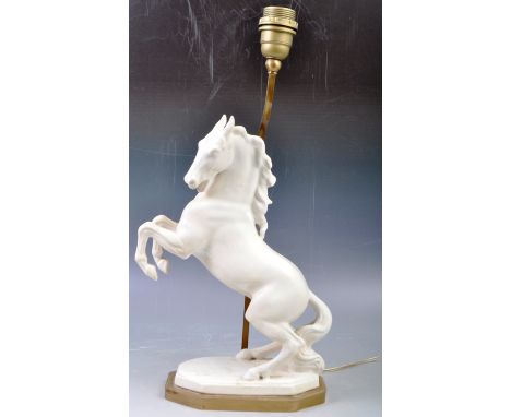An early 20th Century highly decorative table lamp in the form of a blanc de chine wild horse stallion raised on gilded brass