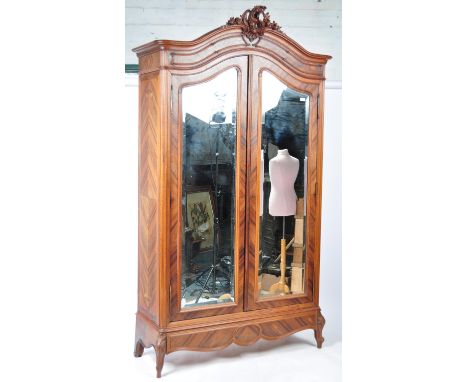An early 20th Century French armoire wardrobe of walnut construction having two full length&nbsp;double bevelled edge mirror 