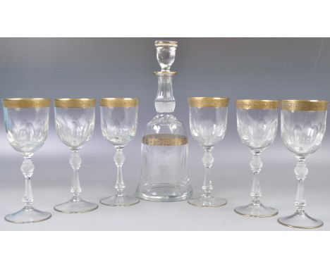 A collection of 20th Century German made Bohemian cut glass wine glasses and decanter with gilded Mintonborde decoration. Com