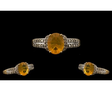 Ladies Attractive 9ct Gold Fire Opal and Diamond Set Ring. The Central Oval Shaped Opal of Orange Colour with Flambe Underton