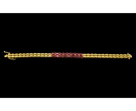 Ruby Band Bracelet, a double row of sixteen oval cut rubies, of rich red with pinkish undertones, totalling 10.5cts, forming 