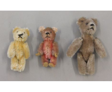 Three Schuco miniature teddy bears, all with black boot button eyes, stitched noses and mouths, the largest in tan (height 9c