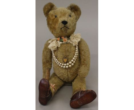 Mohair American teddy bear with boot-button eyes, operative squeaker, stitched nose and mouth, wears pearls, locket and flora