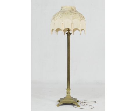 Brass corinthian column extendable standard lamp, having a gold damask and tasselled silk umbrella shade over a reeded column