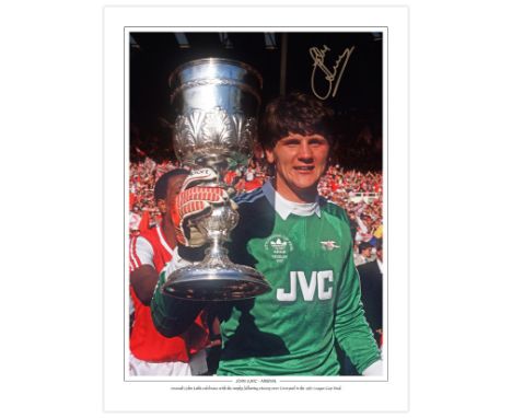 Autographed JOHN LUKIC 16 x 12 Edition : Arsenal goalkeeper JOHN LUKIC holds aloft the League Cup during pitch-side celebrati