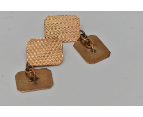 A PAIR OF YELLOW METAL CUFFLINKS, each of a rectangular form with engine turned pattern, chain linked, stamped 9ct, approxima