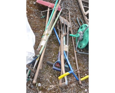 A COLLECTION OF GARDEN TOOLS including rakes, hoes, spades, forks, the claw welder , a hose reel etc