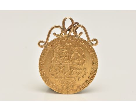 A GEORGE III GOLD GUINEA 4th HEAD MOUNTED COIN, dated 1785, soldered with a yellow metal scrolling surmount, fitted with a ju